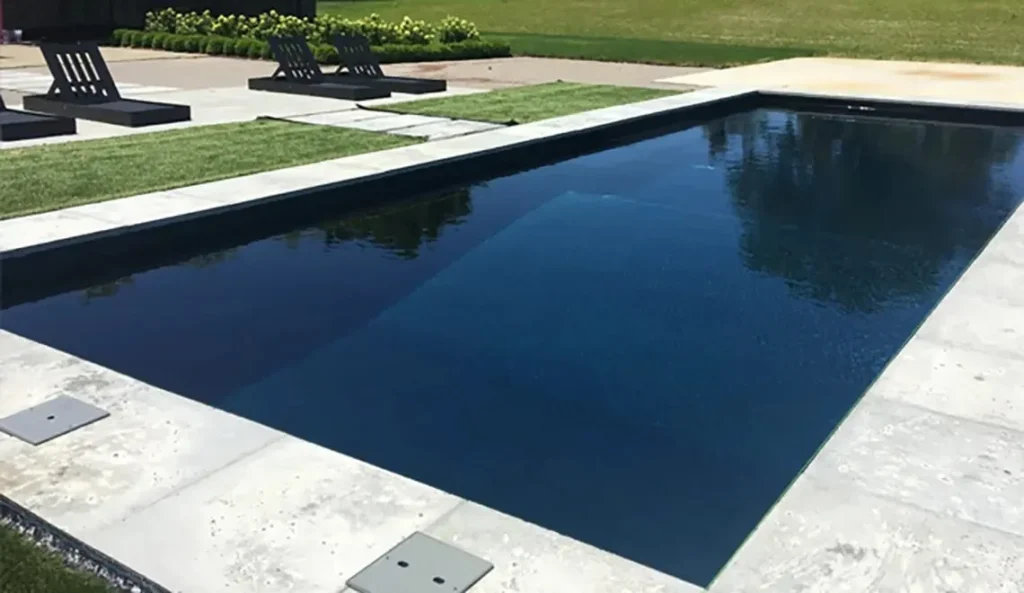 Leisure Grand in a dark finish with stone coping and lawn